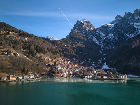 Aerial view of the Alleghe village and Lago di Alleghe on a sunny winter day. Dolomites, Italy