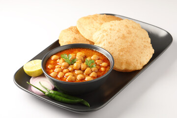 Chole Bhature or Chick pea curry with Fried Puri served in a ceramic plate and bowl