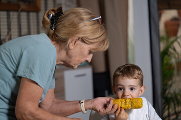 grandmother feeding her two year old grandchild