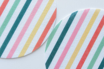 large round felt fabric shapes with colorful and white stripes on blank paper