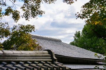 Close-up of the roof of Tenryuji Temple in Kyoto, Japan with trees. Roof tile pattern. Major tourist attraction in Kansai region in Japan. Japan famous historic architecture. Building structure.