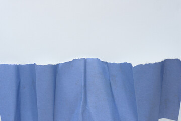 3d crumpled blue paper with torn edge on blank paper