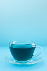Anchan or Butterfly pea tea - cup of blue tea on blue vertical background with copy space