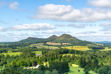 Fototapeta premium Panoramic westerly view from Scott's View near Melrose, UK over landscape near Scottish Borders, overlooking the valley of the River Tweed and the three peaks of the Eildon Hills