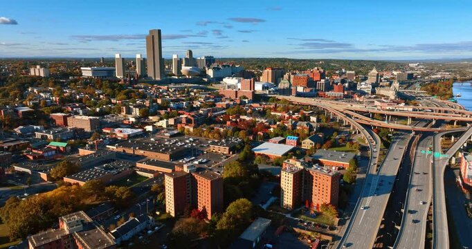Footage above the beautiful scenery of Albany, New York State, USA on sunny day. Cars move by the highways and freeways built along the Hudson River. Aerial view.