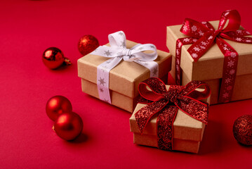 Christmas gift boxes with red balls on red background.