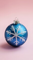 Blue Christmas ornament with snowflake design on pink background, perfect for holiday mockups and designs.