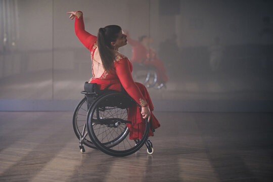 Beautiful dance in a wheelchair of a woman with disability at a dancing studio. Para dance sport.