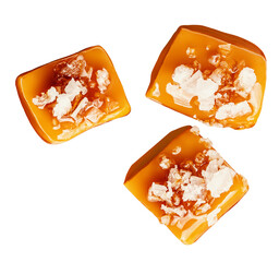 Flying Salty Caramel candies isolated on white. Levitating Salted Caramel fudges with salt crystals
