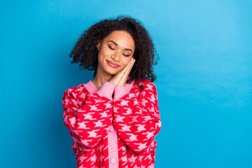 Portrait of american girl with curly hair wearing red stylish cardigan palms together touch cheek...