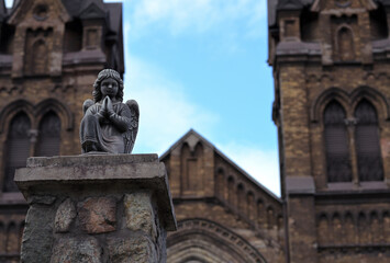 Obraz premium A close-up of an angel sculpture on the stone fence of St. Nicholas Church against the backdrop of the blue sky in the city of Kamianske, Ukraine