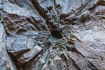a detailed close-up of a rock wall, seemingly marked by an explosion or some form of significant...
