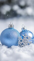 Bright blue glitter Christmas ornaments on snowy background. Perfect for winter and holiday greeting cards.