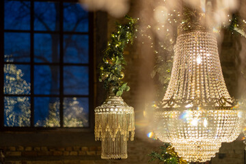 Elegant crystal chandeliers illuminate a festive interior during evening hours in a beautifully...