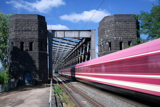 Fernverkehrszug in rasender Fahrt &uuml;ber Eisenbahnbr&uuml;cke zwischen Urmitz und Engers am Rhein - Stockfoto