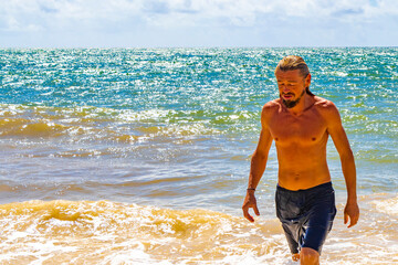 Male tourist man with long hair on Caribbean beach Mexico.