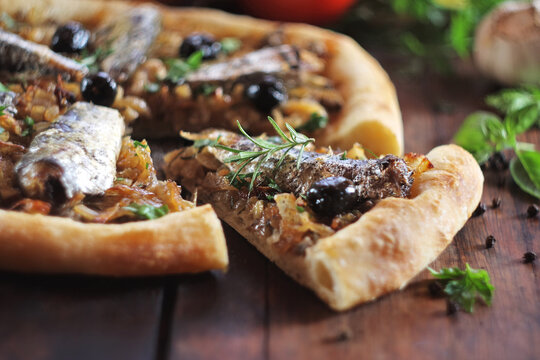 Pizza with sardine, anchovy and black olives. Selective focus.
