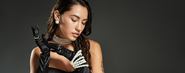 A stunning young woman gracefully poses while displaying her elegant attire and accessories.