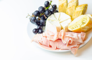 A plate of food with bread, cheese, and grapes