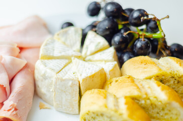 A plate of food with bread, cheese, and grapes