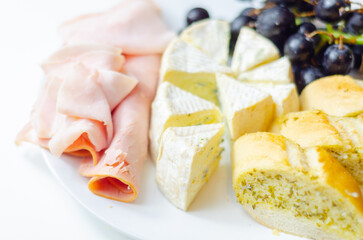 A plate of food with bread, cheese, and grapes