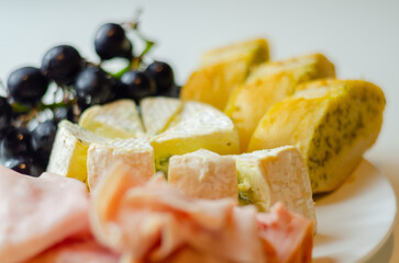 A plate of food with bread, cheese, and grapes