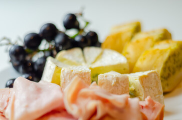 A plate of food with bread, cheese, and grapes