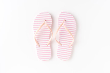 Pair of pink flip flops on white background. Top view