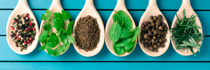 Various spices on wooden spoons