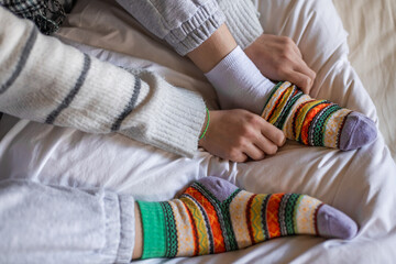 A woman in warm pants putting on a second pair of warm socks to keep warm in the winter without...