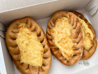 There are three pieces of bread topped with cheese placed in a box