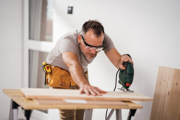 a handsome man making furniture in his new apartment