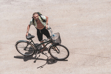 Fototapeta premium Long haired man rides away on a bicycle in Mexico.