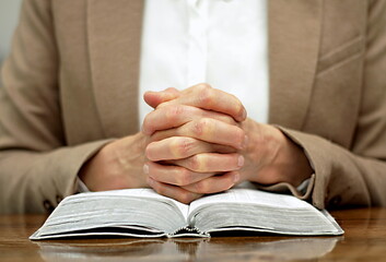 praying to god with hands together with crucifix cross on black background with people stock photo stock image	