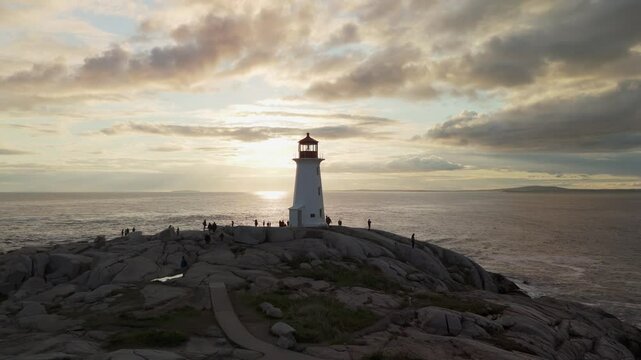 Stunning Aerial View Of Peggy's Cove Lighthouse On A Rocky Shore As The Sun Sets Over The Atlantic Ocean, Creating A Beautiful Scenic View Near Halifax, Nova Scotia.