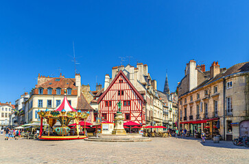 Dijon city historical centre with old typical houses colorful buildings and merry-go-round carousel on La Fontaine Place Francois Rude square, cityscape Dijon old town, Bourgogne region, France