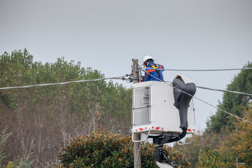 electrician working on aerial platform for electrical maintenance on power line