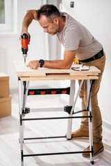 a handsome man making furniture in his new apartment