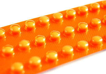 Pills in a blister pack, a macro image of a orange blister drugs on white background