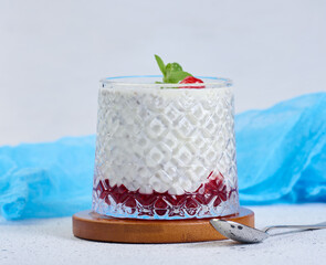 A glass of chia seeds and yogurt, with pomegranate seeds added to the dessert