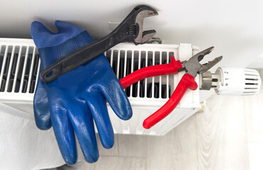 heating system installation and maintenance service. plumber installing radiator
