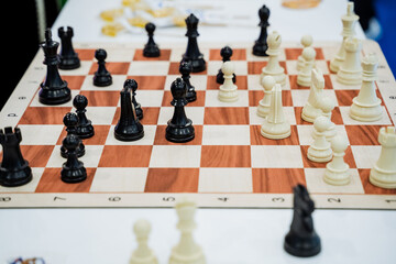 A chess board featuring black and white pieces arranged on it, showcasing a classic and strategic...