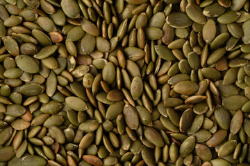 Roasted pumpkin seeds textured background in high resolution. Macro photography.