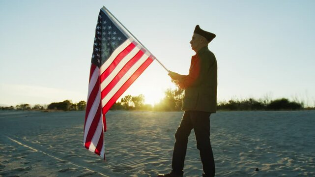 Old Veteran walking in the beach alt sunset with Usa Flag 