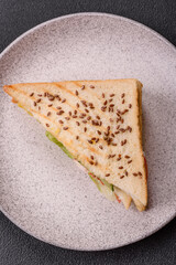 Sandwich with toast bread, meat, tomatoes, cheese, sauce, salt and spices