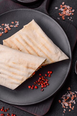 Roll with pita, meat, tomatoes, cheese, sauce, salt and spices