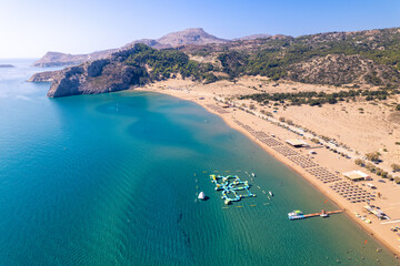 Aerial View of a Serene Beach With Clear Waters, Sandy Shores, and Colorful Water Activities Under a Bright Sky