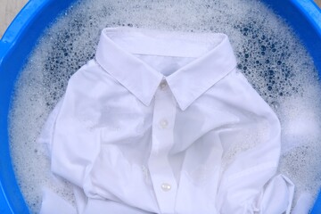 White shirt in suds, closeup. Hand washing laundry