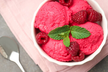 Delicious raspberry sorbet with fresh berries in bowl and spoon on gray table, flat lay