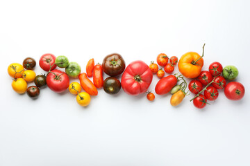 Different ripe tomatoes on white background, flat lay